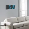 A modern living room with a digital clock on the wall and a sofa in the foreground. Náhled obrázku produktu