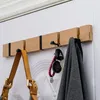 A wooden coat rack mounted on a white door, holding a handbag, keys, and a jacket. Produktbild-Vorschau