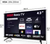 A 43-inch RCA Roku Smart TV is shown with its screen displaying various app icons and information, including dimensions and VESA mount compatibility. Podgląd zdjęcia produktu