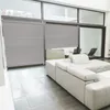 A modern living room with large windows and blinds, featuring a white sectional sofa. Produktbild-Vorschau