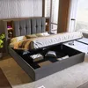 A modern bedroom with a large upholstered bed with storage, showing the lift-up mattress revealing the storage space underneath. Produktbild-Vorschau
