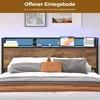 A bed with a headboard featuring LED lighting and storage shelves, decorated with items like books, a phone, and a tablet. Produktbild-Vorschau