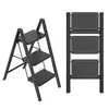 Two views of a black metal step stool with three steps, shown against a white background. Náhled obrázku produktu