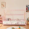 A child's pink house-shaped bed with white railings and bedding, decorated with fairy lights. Anteprima dell’immagine prodotto
