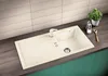 A kitchen sink with a faucet, drain, and a drying rack area, set against a tiled backsplash and a countertop. Produktbild-Vorschau
