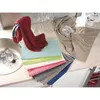 A collection of colorful kitchen towels are neatly stacked on a countertop next to a sink and wine glasses. Produktbild-Vorschau