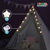 A child's teepee tent set up indoors at night, decorated with star-shaped string lights. Produktbild-Vorschau