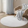 A round white rug is placed on a wooden floor in front of a beige armchair with a light gray blanket draped over it. A magazine is on the armchair. A sheer light gray curtain is in the background. Anteprima dell’immagine prodotto