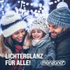 A family smiling and posing in front of blurred Christmas lights. Voir les images du produit