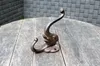 A cast iron elephant-shaped hook is displayed on a wooden table against a brick-like background. Produktbild-Vorschau