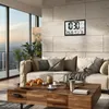 A living room with a sofa, coffee table, and a digital clock on the wall. Produktbild-Vorschau