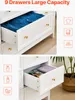 Close-up views of white drawers of a dresser, one filled with blue folded clothes, another with books and glasses. Icons representing clothing, towels, hats, soap, lipstick, and a duck are shown on the left and right sides. Voir les images du produit