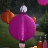Several paper lanterns are hanging outdoors, with a table set for drinks in the foreground. Podgląd zdjęcia produktu