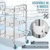 A stainless steel rolling cart with three shelves, shown in a laboratory or clinic setting. Text overlays highlight assembly ease and secure fastening. Produktbild-Vorschau
