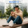 A young man is sitting on a bench outdoors, wearing headphones and looking at his phone. Produktbild-Vorschau