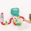 A child's hand interacting with a LUDI water experiment lab toy attached to a tiled wall, likely in a bathroom. Produktbild-Vorschau
