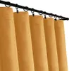 A close-up view of several mustard yellow curtains hanging from a black curtain rod. Náhled obrázku produktu