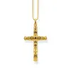 A gold-colored cross pendant with black accents, displayed on a white background. Náhľad obrázku produktu