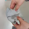 Hands holding a light gray PVC pipe insulation fitting. Produktbild-Vorschau