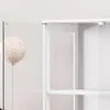 A close-up view of a white glass display cabinet with a balloon in the foreground. Náhled obrázku produktu
