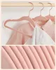A close-up view of pink velvet hangers holding children's clothing. Náhled obrázku produktu