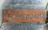 A rusty metal sign with the word "Lieblingsplatz" cut out, placed on a wooden surface. Produktbild-Vorschau