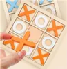 A hand is placing an orange 'X' piece onto a wooden tic-tac-toe board. Náhled obrázku produktu