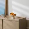 A wooden sideboard with a bowl of oranges on top, next to a mirror. Produktbild-Vorschau