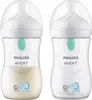 Two Philips Avent baby bottles are shown side-by-side against a white background. The bottle on the left contains a cream-colored liquid, while the bottle on the right is empty. Both bottles have a clear body, white collar and cap, and a teal-colored valve Produktbild-Vorschau