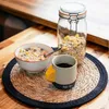 Keramiktasse "Climbing Mug Evo" von YY Vertical mit Klettergriff; auf einem Tisch neben einer Schüssel Müsli und einem Glas. Podgląd zdjęcia produktu