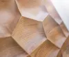 A close-up view of a wooden surface with a geometric, faceted design. Produktbild-Vorschau