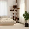 A cat tree is placed in a bedroom next to a bed, with a cat on the cat tree. Náhľad obrázku produktu