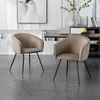 Two beige upholstered chairs with black metal legs are shown in a dining room setting. Produktbild-Vorschau