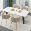 A dining set with a marble-top table and four chairs, set on a rug. Anteprima dell’immagine prodotto