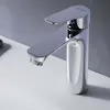 A close-up shot of a modern chrome faucet on a white sink against a light gray wall. Produktbild-Vorschau