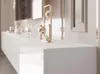 A close-up view of a white, high-gloss TV lowboard with decorative gold objects on top. Voir les images du produit
