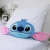 A blue Stitch plush pillow is placed on a white bed. Voir les images du produit