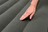 A hand touching a gray air mattress. Náhled obrázku produktu