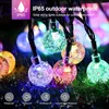 Close-up of colorful solar string lights with water droplets, set against a dark, blurred background. Produktbild-Vorschau