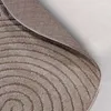 A close-up view of a round rug with a concentric circle pattern, showing the texture and underside of the rug. Anteprima dell’immagine prodotto