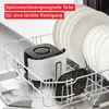 An air fryer basket and parts are placed in a dishwasher rack alongside plates. Produktbild-Vorschau