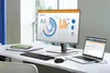 A desk setup with a laptop and an external monitor displaying data charts. Voir les images du produit