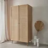 A wooden wardrobe with rattan doors stands in a room with sheer curtains and decorative vases. Produktbild-Vorschau