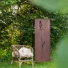 A garden scene with a chair and a decorative metal screen. Podgląd zdjęcia produktu