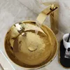 A gold basin faucet with water flowing into a gold basin. Anteprima dell’immagine prodotto