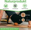 A person is using a cork massage ball on their hip during a yoga or exercise session. Produktbild-Vorschau