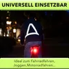 A person riding a bicycle at night, wearing a reflective vest. Produktbild-Vorschau