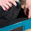 Hands are shown placing black foam into a blue case. Produktbild-Vorschau