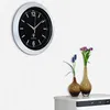 A wall clock is mounted on a textured white wall, with two vases of flowers on a white cabinet below it. Anteprima dell’immagine prodotto