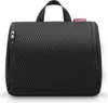 A black toiletry bag with a textured surface and a red brand tag. Produktbild-Vorschau